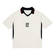 ParkzBus cream waffle-knit polo shirt with navy and burgundy v-neck collar, black side panels, and embroidered three lions crest on chest
